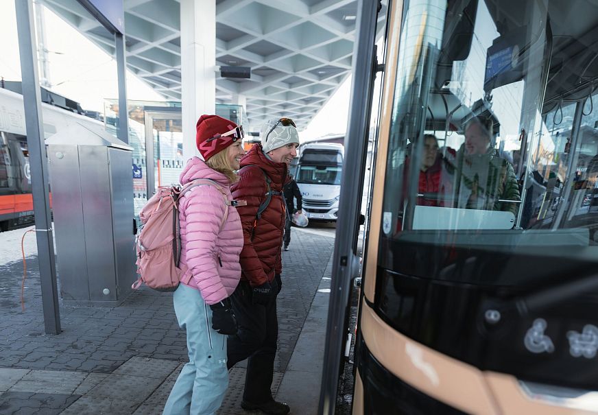 Winterwandern in der Region Seefeld_Mann und Frau steigen in Bus in Seefeld ein