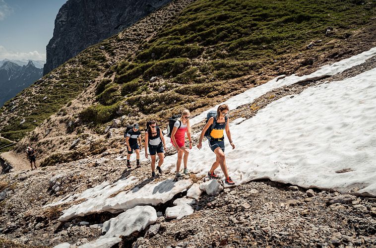 Wanderguppe im Aufstieg auf das Scharnitzjoch durch das Puittal mit Schneefeld