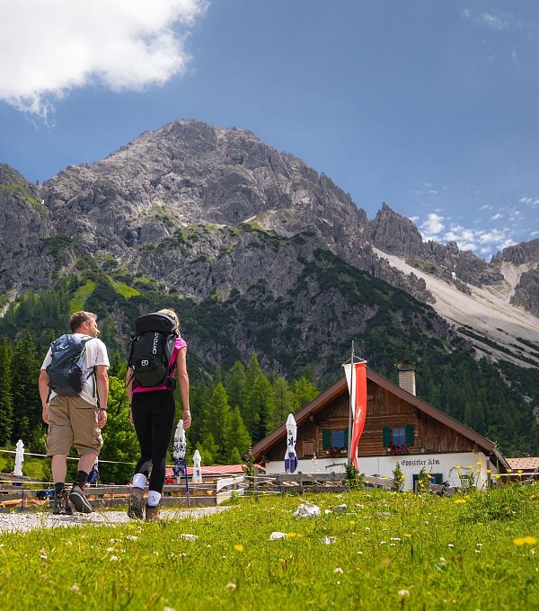 Wanderung zur Eppzirler Alm im Sommer - Mann und Frau von hinten mit Eppzirler Alm (1)
