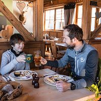 Ein Mann und ein Junge stoßen in einer rustikalen Gaststätte an.