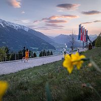 Paar spaziert bei Sonnenuntergang in den Alpen der Region Seefeld. Fahnen im Wind, Berge im Hintergrund.