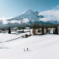 Zwei Langläufer in der Region Seefeld, umgeben von verschneiten Bergen und Wald.