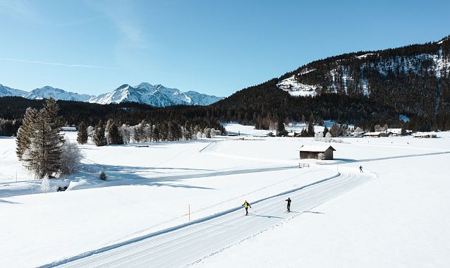Langläufer in der verschneiten Region Seefeld vor beeindruckender Bergkulisse.