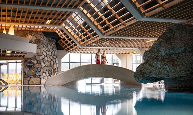 Olympiabad Seefeld - Paar läuft über Brücke im Schwimmbadbereich