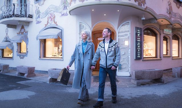 Ein Paar geht in einer dekorativen Einkaufsstraße. Keywords: Einkaufen, Spaziergang