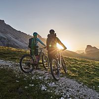 Radfahrer bei Sonnenaufgang in der Region Seefeld, Berge im Hintergrund. Mountainbiken im Morgenlicht.