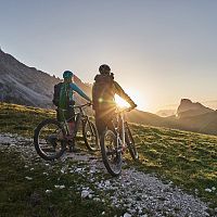 Radfahrer bei Sonnenaufgang in der Region Seefeld, Berge im Hintergrund. Mountainbiken im Morgenlicht.