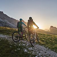 Radfahrer bei Sonnenaufgang in der Region Seefeld, Berge im Hintergrund. Mountainbiken im Morgenlicht.